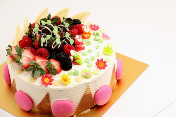 Round vanilla cake decorated with fresh fruits