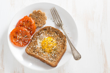 fried egg in toast, grilled tomatoes for breakfast on a plate