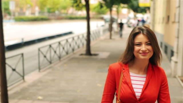 Woman walking on the street and smiling, steadycam shot