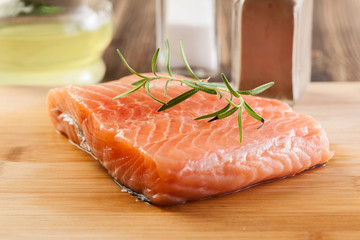 Raw salmon filet on wooden cutting board