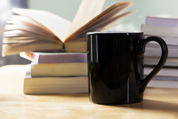 Fototapeta premium black coffee cup and book pile