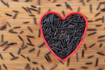 Wild black rice heap in a heart bowl.