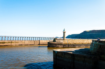 Scenic view of Whitby Pier in sunny day in North Yorkshire, UK.