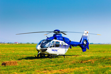 Fototapeta na wymiar Police helicopter on a green grass field preparing to take off