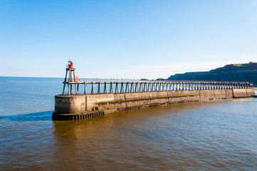 Fototapeta na wymiar Scenic view of Whitby Pier in sunny day in North Yorkshire, UK.