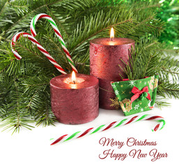 Two red candles with natural conifer and canes