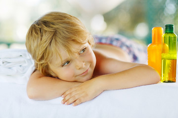 Little kid boy relaxing in spa with having massage