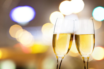 Champagne glasses against holiday lights