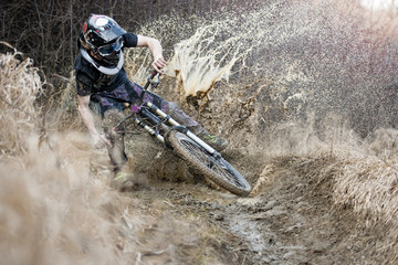 Obraz premium Mountainbiker crosses through the mud