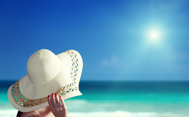 woman wearing hat and sunny beach