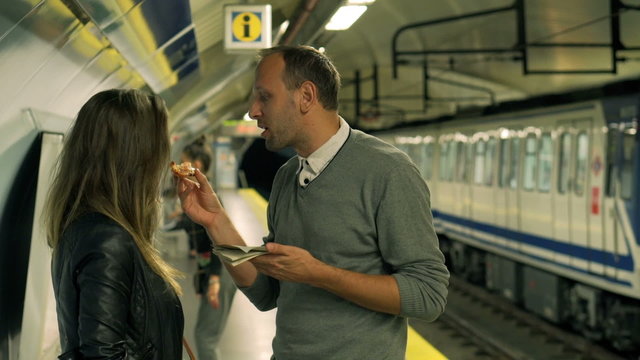 Boyfriend feeding his girlfriend on the station, steadycam shot