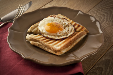 Scrambled eggs with toast on brown plate wooden table