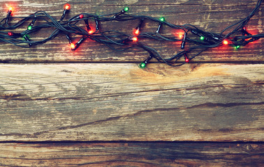Colorful Christmas lights on wooden  rustic background. retro fi