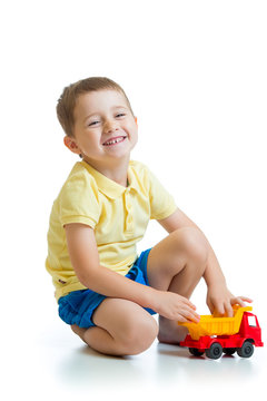 funny kid playing with lorry toy isolated on white