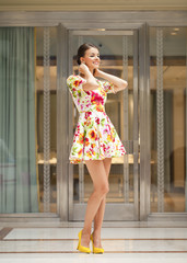 Obraz premium Beautiful woman in red flowers dress in the shop