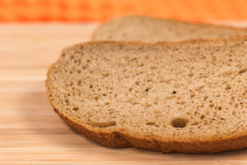 Two slices of rye bread on a wooden table