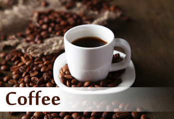 Cup of coffee and coffee beans on wooden background