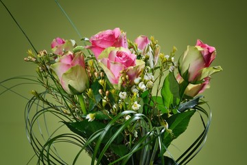 Bouquet of pink roses on green background.
