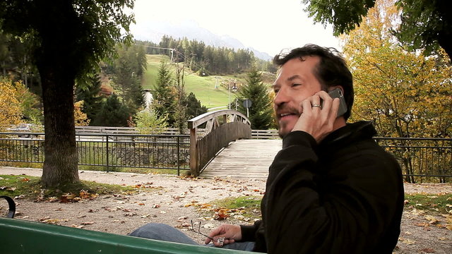 Happy man talking on the phone in the mountain