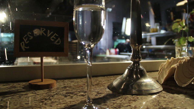 Dull lights of restaurant, champagne glass on reserved table