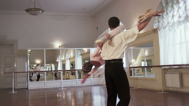 Classical ballet dancing, man flips woman upside down and twirls