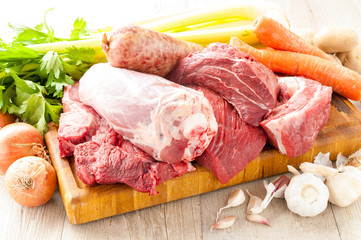 Tagli di carne bovina e suina cruda appoggiati sul tagliere