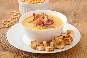 Cream soup of peas with fried bacon and croutons