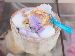Fototapeta na wymiar Coconut milk ice-cream in coconut shell strew with ground nut