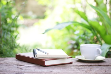 Notebook  and coffee on wooden table