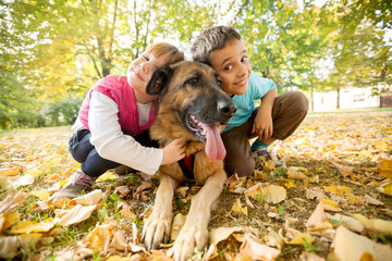 children in the park with a German Shepherd