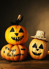 Halloween pumpkins on wooden table on dark color background