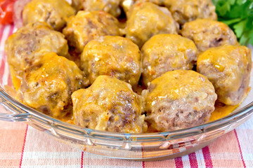 Meatballs with sauce in glass pan on tablecloth