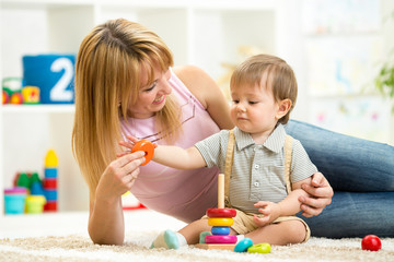 cute mother and child boy play together indoor at home