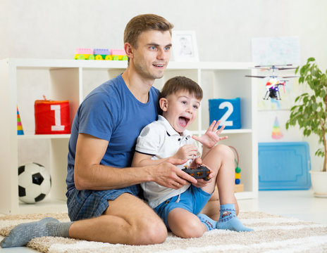 Father and son playing with RC helicopter toy