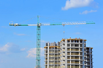 Crane and building construction site against blue sky