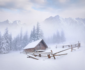 Old farm in the foggy winter mountains