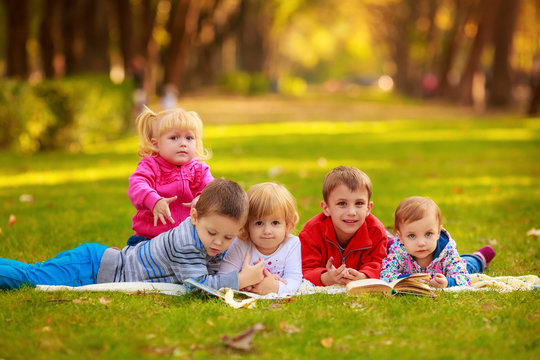 children in nature. reading a book outdoors lying on the grass
