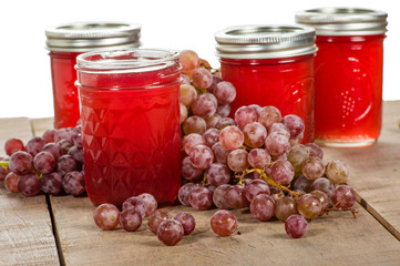 Pink grapes with jars of grape jelly