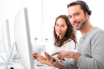 Young attractive man working in a call center