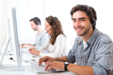 Fototapeta na wymiar Young attractive man working in a call center