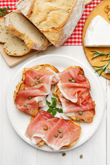 Sandwich with rye bread with aromatic, smoked ham and capers