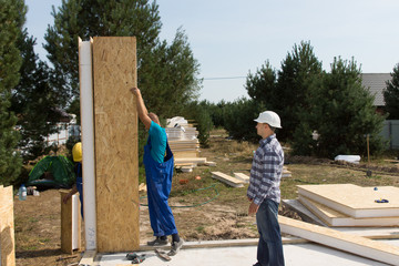 Builders erecting insulated wall panels