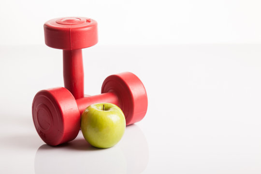 Red dumbbells weight with green apple