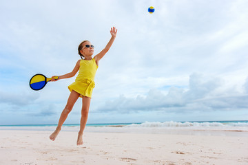 Little girl playing beach tennis