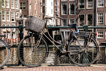 Fototapeta na wymiar Amsterdam with bicycles on the bridge against canal in Holland