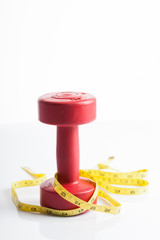 Red dumbbells weight with measuring tape