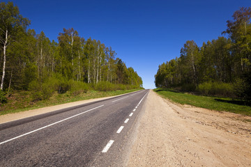 Fototapeta premium the asphalted road - the small rural asphalted road photographed in summertime of year. Belarus