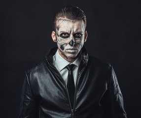 Portrait of pensive man with make-up  skull