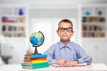 Cute schoolboy is writting 