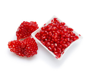 Loose pomegranate seeds in a white bowl
